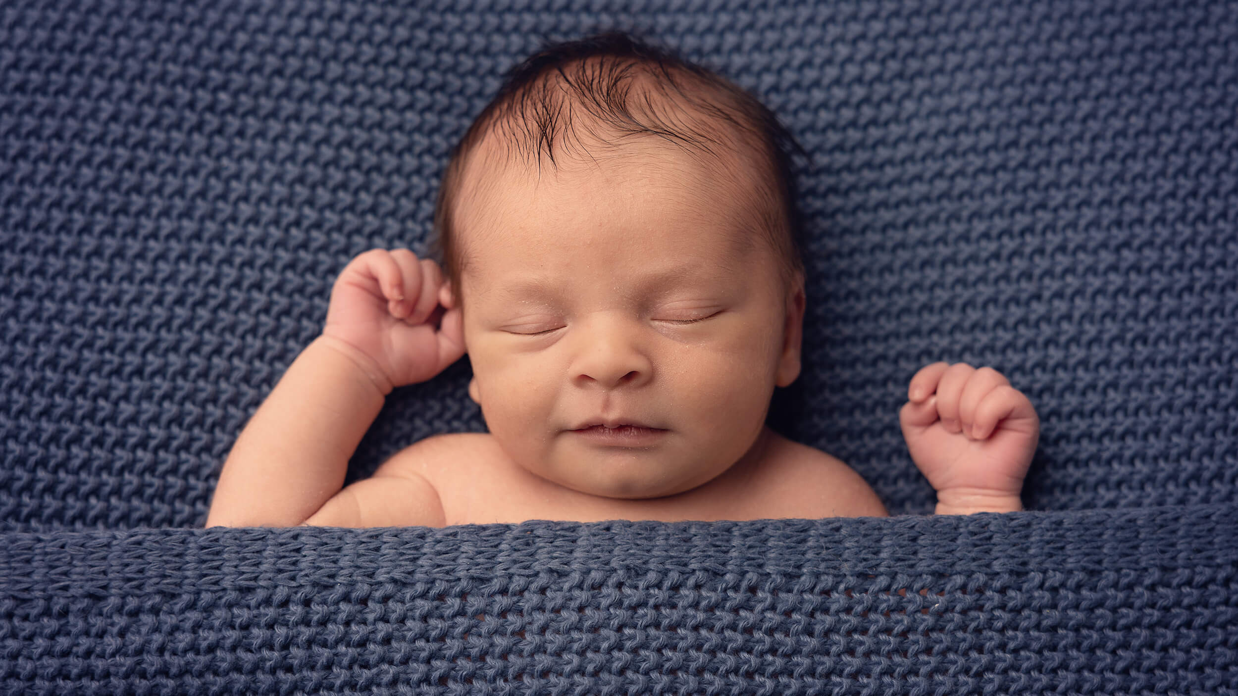 Baby boy on a blue blanket at a photo session in Cornwall with AnA Photography