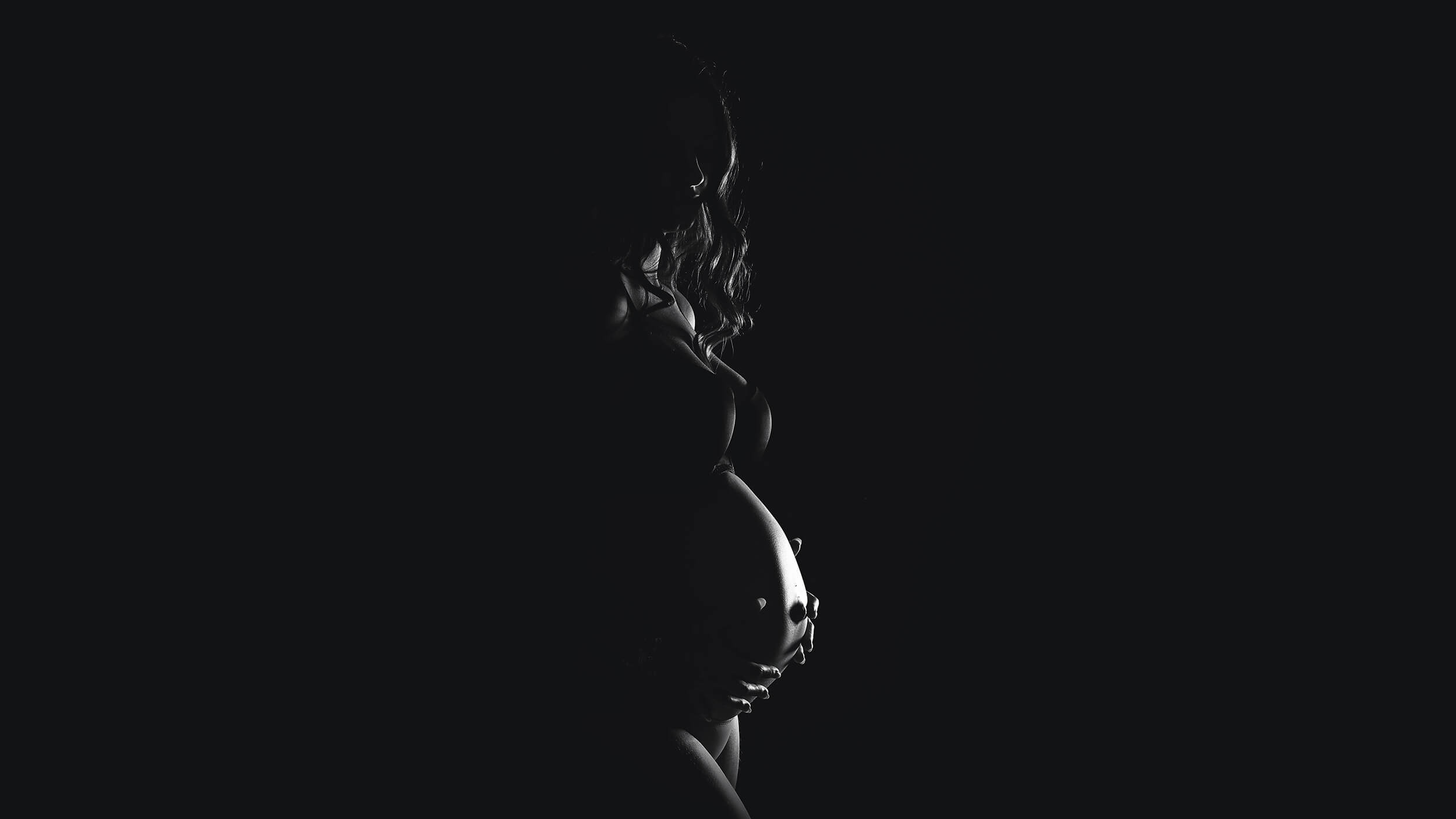 Dark pregnancy maternity photo from a session at AnA Photography in Cornwall.