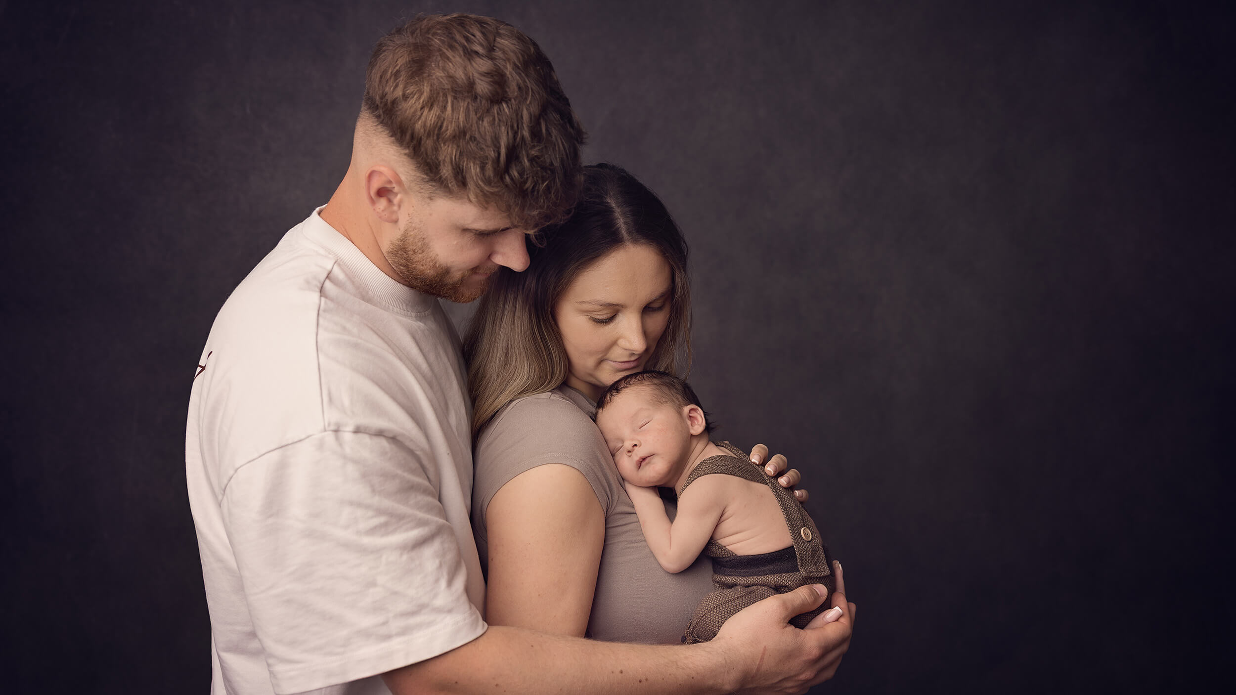 Mum, Dad and Newborn Baby posed at a photo shoot in Bodmin Cornwall with AnA Photography.
