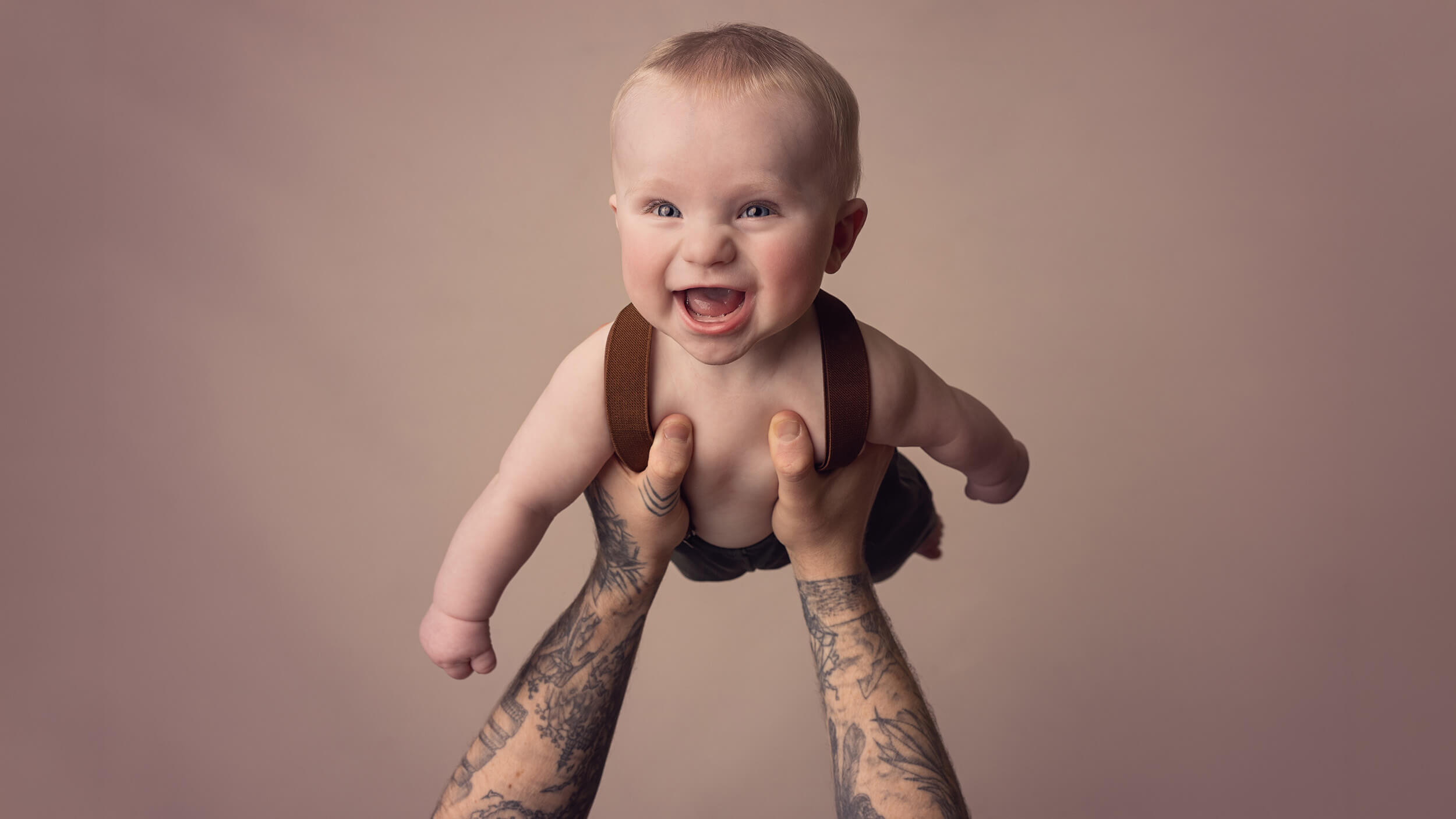 a toddler flying in Dads arms during a photoshoot with Cornwall photography studio AnA Photography.